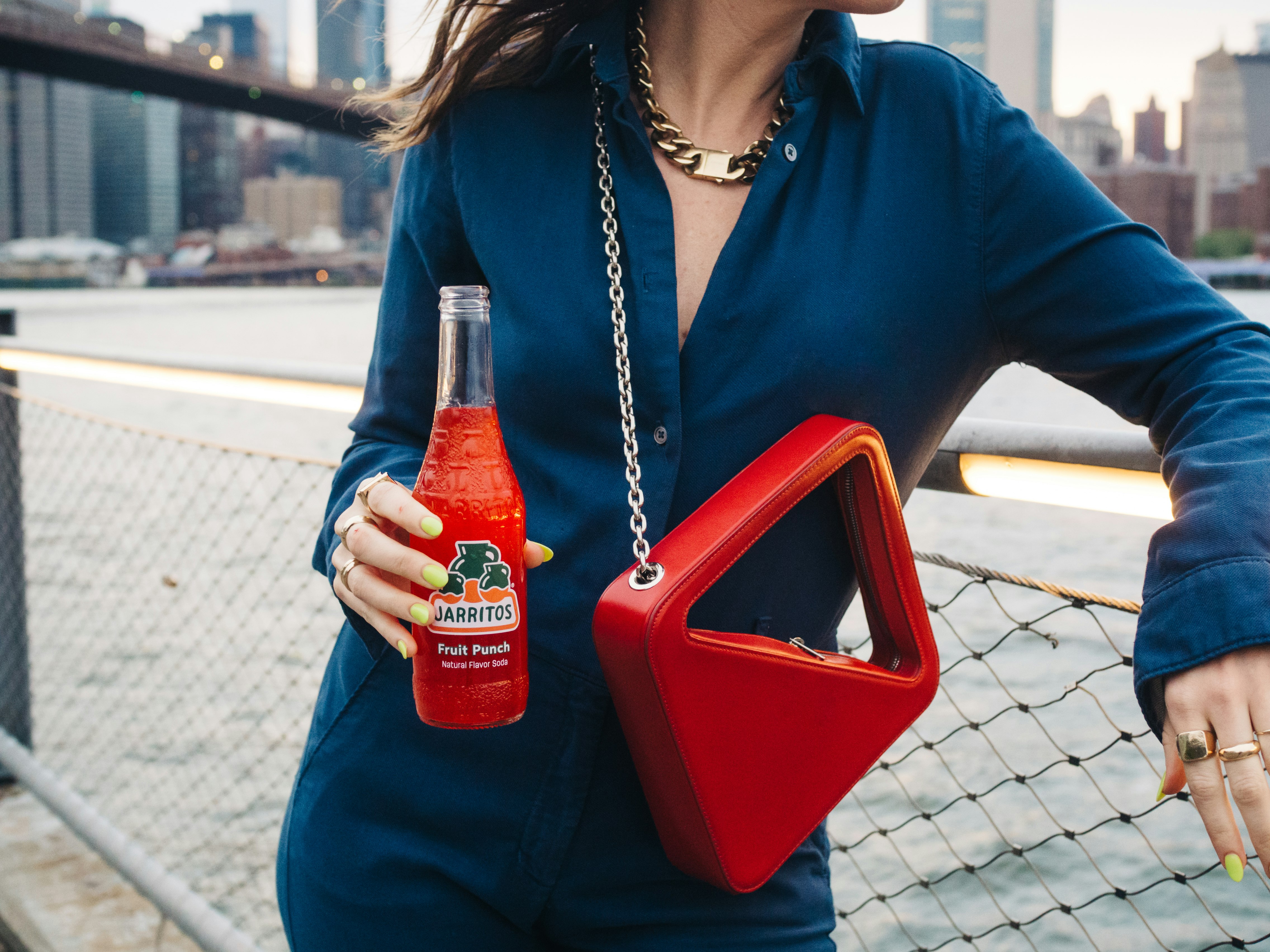 woman in blue dress shirt holding red plastic container